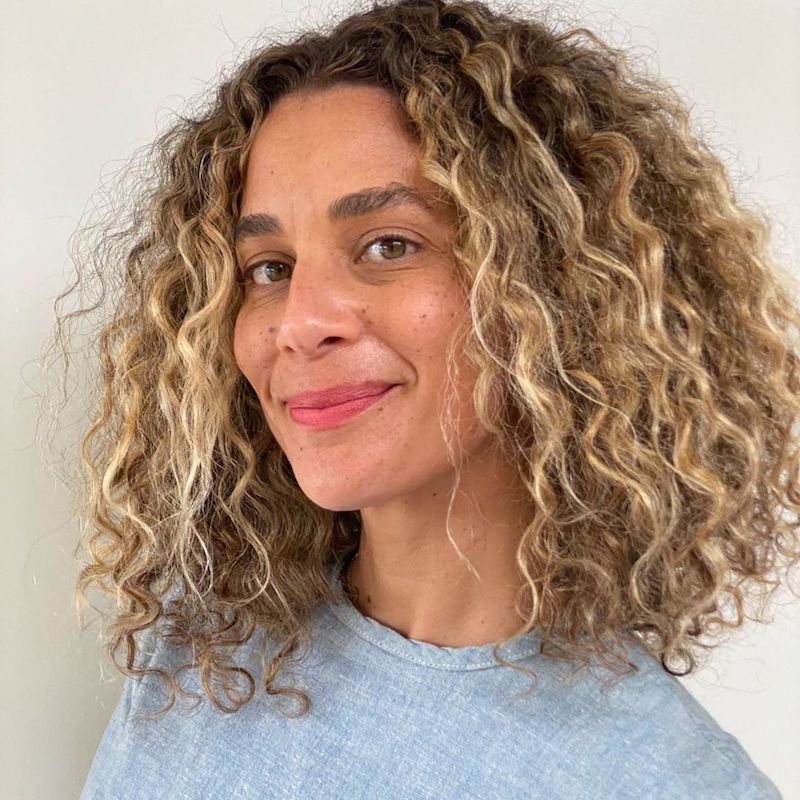 Beach-kissed lived-in color by Johnny Ramirez — natural blonde on soft curls.